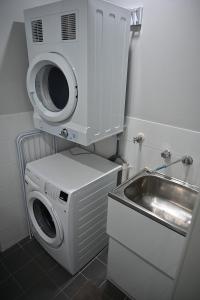 a washing machine and a sink in a bathroom at Bowman's Place in Guildford