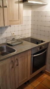 a kitchen with a sink and a stove at Domaine du Manoir de Vains in Vains