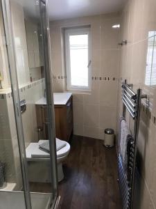 een badkamer met een toilet en een glazen douche bij Ashley Croft in Skipton