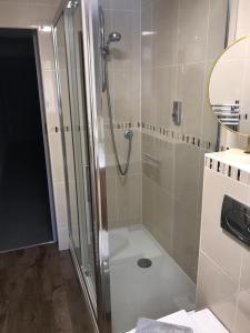 een douche met een glazen deur in de badkamer bij Ashley Croft in Skipton