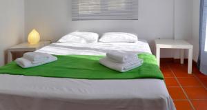 1 dormitorio con 1 cama con toallas en Village Holiday House Nick, en Agia Paraskevi