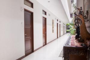 un couloir vide avec des portes en bois dans un bâtiment dans l'établissement RedDoorz Near Trans Studio Mall 3, à Bandung