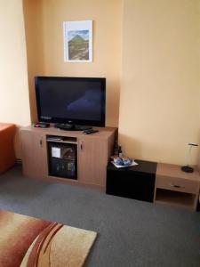a living room with a flat screen tv on a stand at Hotel Maria in Ostrava