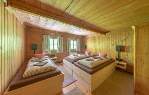 a bedroom with two beds in a wooden cabin at Großmutters Haus in Westendorf