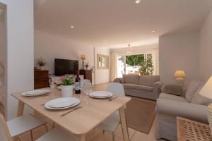 una sala de estar con una mesa con platos y copas de vino en Fantastic 3 Bedroom Townhouse Golf Del Sur - The Palms Resort, en San Miguel de Abona