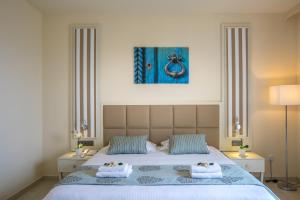 a bedroom with a large bed with two pillows at Aquamare Beach Hotel & Spa in Paphos