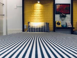 a bed in a room with a yellow wall at Friendly House Hostel in Hue