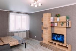 Schlafzimmer mit einem Bett und einem Flachbild-TV in der Unterkunft Luxury apart-hotel on Kharkovskaya near Lavina in Sumy