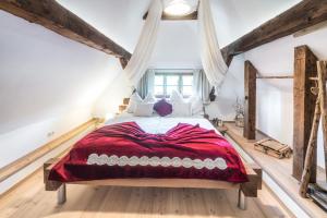 a bedroom with a large bed with a red blanket at Charmante Ruheoase - exklusives Naturjuwel in Oberhaag