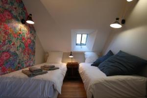 a attic room with two beds and a window at Domaine du Manoir de Vains in Vains