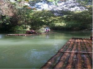 a person standing on a raft in a river at Reggae Moon Guesthouse in Falmouth +17 photos