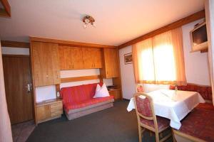マトライ・イン・オストティロルにあるHaus Meixnerのベッドと赤いソファが備わる客室です。