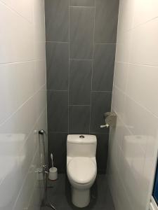 a bathroom with a white toilet in a stall at Landed Cozy House Near SPICE, Airport in Kampong Manggis +13 photos