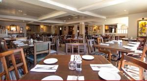 a restaurant with wooden tables and chairs in a room at The Cherry Tree Rochford in Rochford