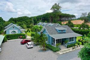 a blue house with a car parked in a driveway at Little Cottage in Chanthaburi