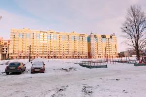 ein Parkplatz mit Autos vor einem großen Gebäude in der Unterkunft Luxury apart-hotel on Kharkovskaya near Lavina in Sumy