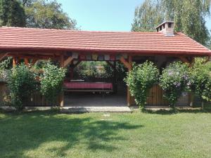 einem hölzernen Pavillon mit einer Bank im Hof in der Unterkunft Zergeboglár Vendégház in Szilvásvárad