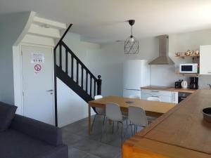 a kitchen and dining room with a table and chairs at LA ROLANDE in Penmarch