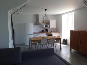 uma cozinha e sala de jantar com mesa e cadeiras em LA ROLANDE em Penmarcʼh