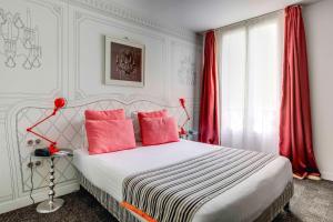 
a bed room with a white bedspread and a red bedspread at Hotel Joyce - Astotel in Paris

