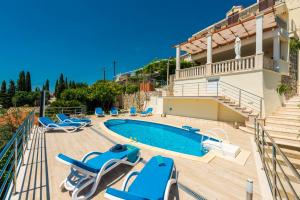 a villa with a swimming pool and lounge chairs at Villa Sunce in Orasac