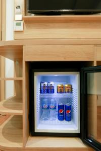 a small refrigerator with cans of soda in it at Prague Saigon Airport Hotel in Ho Chi Minh City