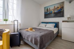 a bedroom with a bed with a hat and a suitcase at Apartament w centrum Starówki Old Town in Gdańsk