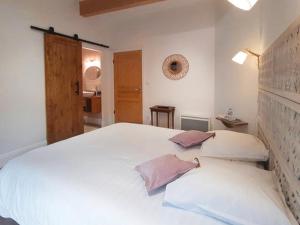 1 dormitorio con 1 cama blanca grande y 2 almohadas en Ô Joly Valois en Hauterives