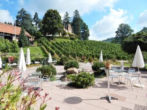 a patio with chairs and tables and umbrellas at Wein Lodge Durbach - Josephsberg in Durbach