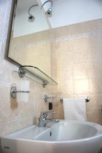 La salle de bains est pourvue d'un lavabo et d'un miroir. dans l'établissement B&B La Villetta, à Breno