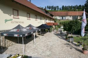 une cour avec des parasols en face d'un bâtiment dans l'établissement Wein Lodge Durbach - Josephsberg, à Durbach