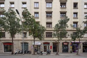 un grand bâtiment avec des motos garées devant lui dans l'établissement Casa Cosi - Atico, à Barcelone
