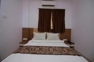 a bedroom with a large bed with a window at Hotel Apex in Navi Mumbai