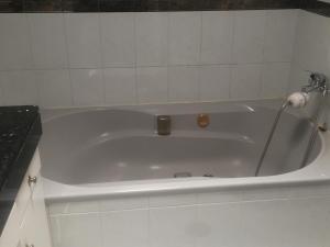 a white bath tub in a white tiled bathroom at Mi casa in Puerto del Rosario