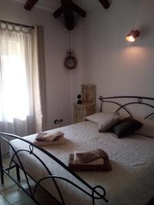 a bedroom with a large bed and a window at Entula 'E Mari Bed&Brakfast in Tortolì