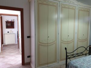 1 dormitorio con un gran armario verde junto a una cama en case vacanze, La casa di Angelo, con terrazzo en Oria