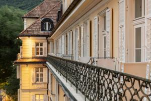 a balcony of a yellow building with a window at Parkhotel Laurin in Bolzano