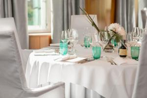 a white table with wine glasses and flowers on it at Parkhotel Laurin in Bolzano