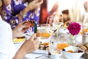 Eine Gruppe von Menschen, die an einem Tisch sitzen und Essen essen. in der Unterkunft Parkhotel Laurin in Bozen