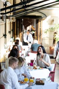 a group of people sitting at a table in a restaurant at Parkhotel Laurin in Bolzano