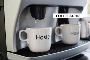 two cups of coffee are being brewed in a microwave at The Common Hostel in Chiang Mai