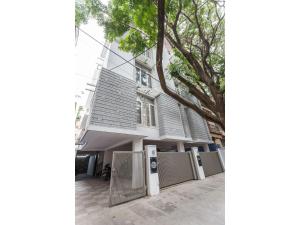 une maison blanche avec une clôture devant elle dans l'établissement Olive Service Apartments - Koramangala, à Bangalore