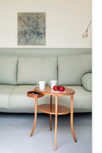 a coffee table with two cups and apples on a couch at Parkhotel Laurin in Bolzano