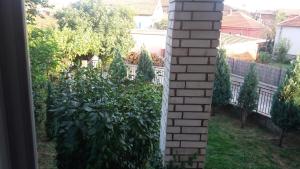 een tuin met een hek en een bakstenen pilaar bij Apartman Lela in Vranje