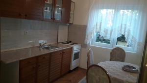 a kitchen with a sink and a stove and a window at Apartman Lela in Vranje