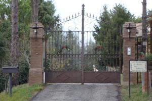 an entrance to a gate with an iron fence at Podere Caldaruccio La Pineta in Bosco