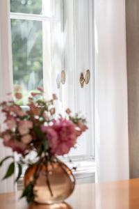 a vase of flowers sitting on a table next to a window at Parkhotel Laurin in Bolzano