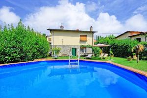 una grande piscina blu di fronte a una casa di Casa al Bosco by PosarelliVillas ad Ameglia