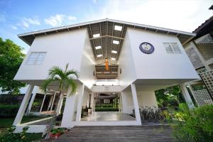 une maison blanche avec une horloge. dans l'établissement Krodyle Mindfulness House, à Phra Nakhon Si Ayutthaya