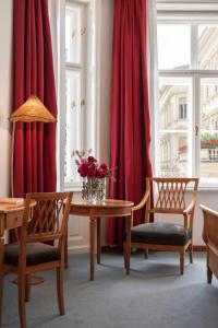 a dining room with red curtains and a table and chairs at Parkhotel Laurin in Bolzano
